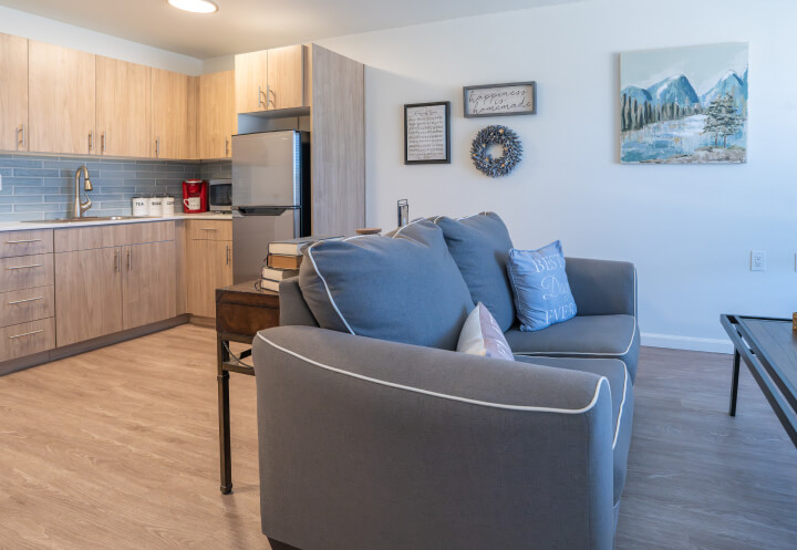 Apartment Living Area With Kitchen and Comfortable Seating Space at Independent Living Facility Apartment Living Area With Kitchen and Comfortable Seating Space at Independent Living Facility