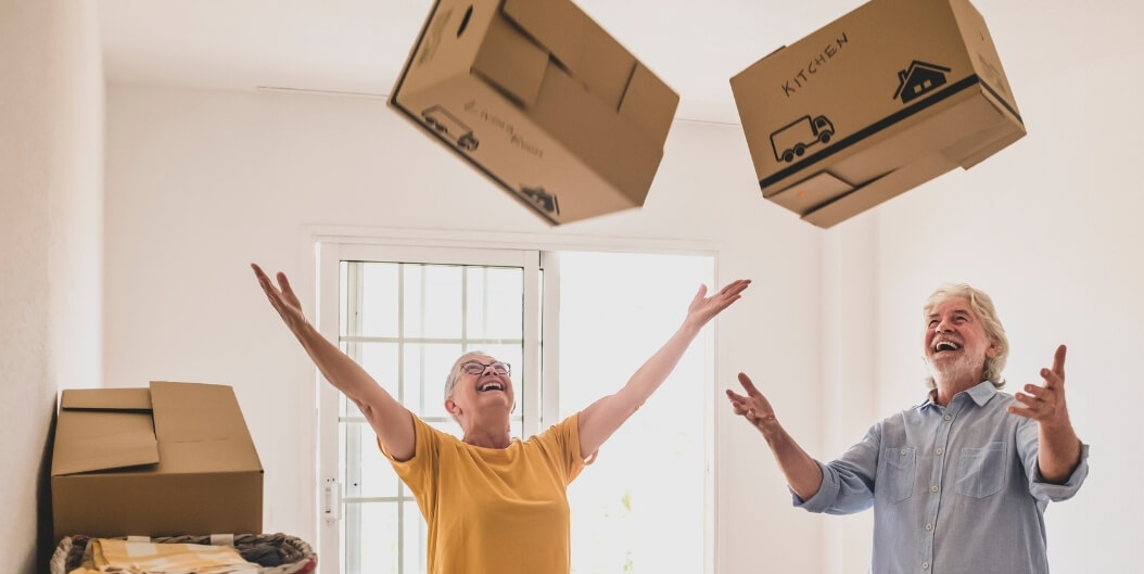 Elderly Couple Tossing Moving Boxes in a New Apartment at an Independent Living Facility
