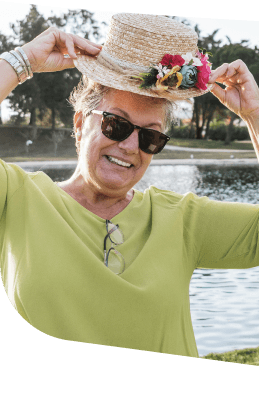 Smiling Elderly Woman Wearing Sunhat and Sunglasses Outdoors at Independent Living Facility Smiling Elderly Woman Wearing Sunhat and Sunglasses Outdoors at Independent Living Facility