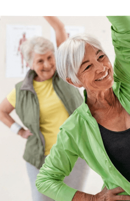 Two Elderly Women Stretching During Group Exercise Class at Independent Living Community Two Elderly Women Stretching During Group Exercise Class at Independent Living Community