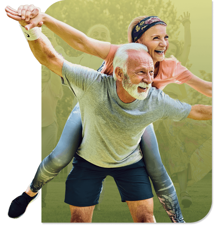 Joyful Elderly Couple Playing Piggyback Outdoors on Grass in Independent Living Joyful Elderly Couple Playing Piggyback Outdoors on Grass in Independent Living