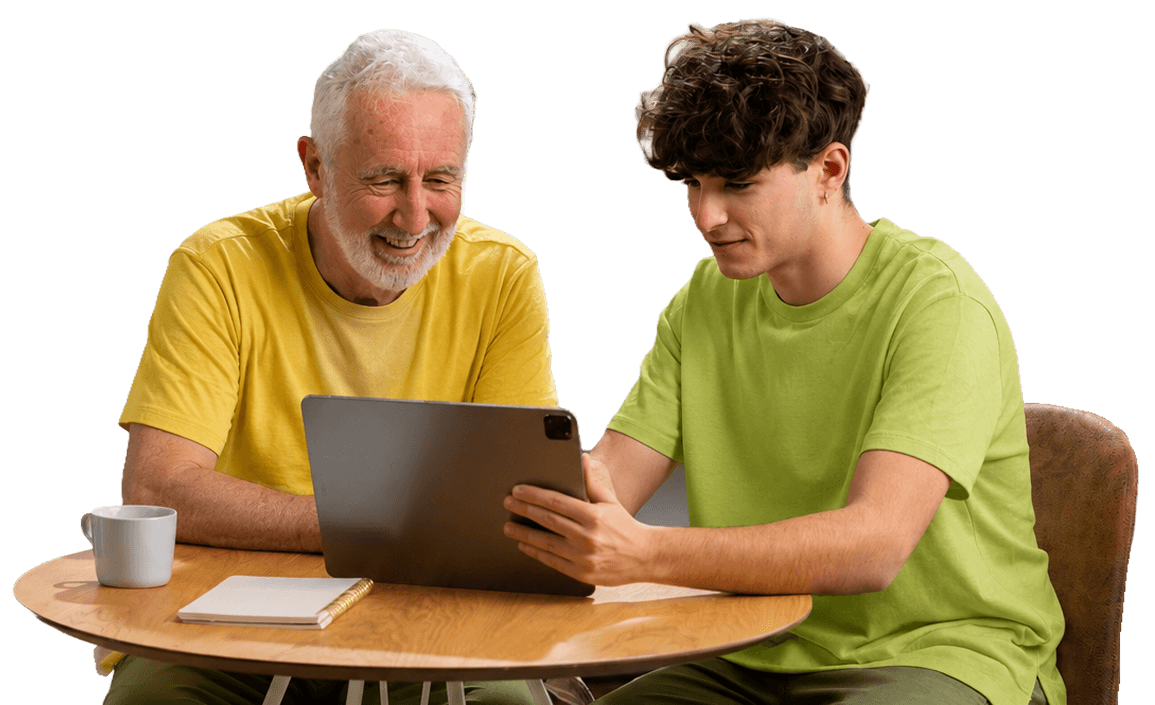Smiling Elderly Man Viewing a Tablet with Young Visitor at Independent Living Facility Smiling Elderly Man Viewing a Tablet with Young Visitor at Independent Living Facility