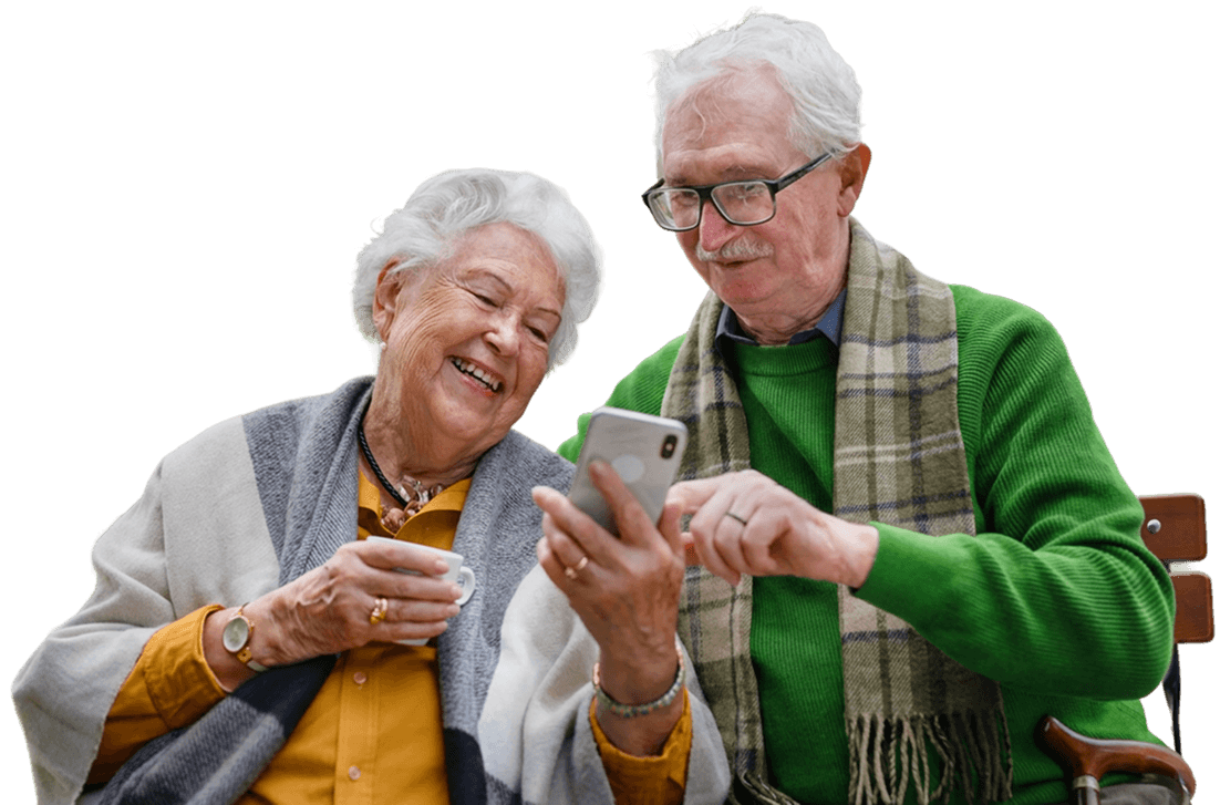 Elderly Couple Smiling While Looking at Smartphone Together at Independent Living Facility Elderly Couple Smiling While Looking at Smartphone Together at Independent Living Facility