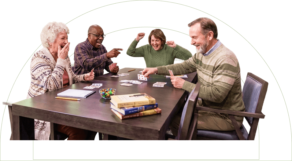 Elderly Friends Laughing While Playing Cards Together at Independent Living Community Elderly Friends Laughing While Playing Cards Together at Independent Living Community