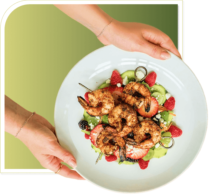 Hands Serving Fresh Grilled Shrimp Salad with Berries at Independent Living Facility Hands Serving Fresh Grilled Shrimp Salad with Berries at Independent Living Facility