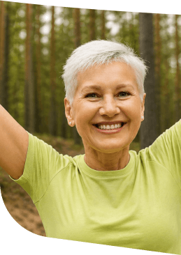 Smiling Elderly Woman Stretching Outdoors Among Tall Trees in Independent Living Smiling Elderly Woman Stretching Outdoors Among Tall Trees in Independent Living
