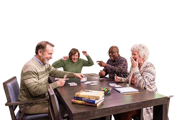 Elderly Friends Laughing and Cheering During Card Game at Independent Living Facility