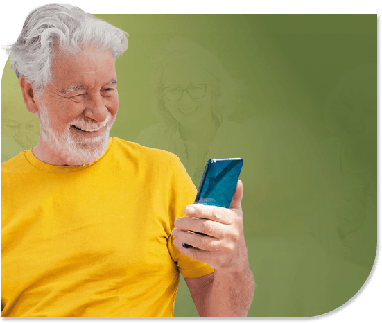 Smiling Elderly Man Looking at Smartphone Screen Indoors in Independent Living Smiling Elderly Man Looking at Smartphone Screen Indoors in Independent Living