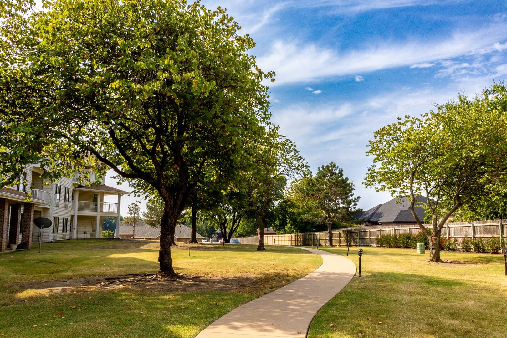 Shaded Walking Path through Green Lawn beside the Building in Independent Living