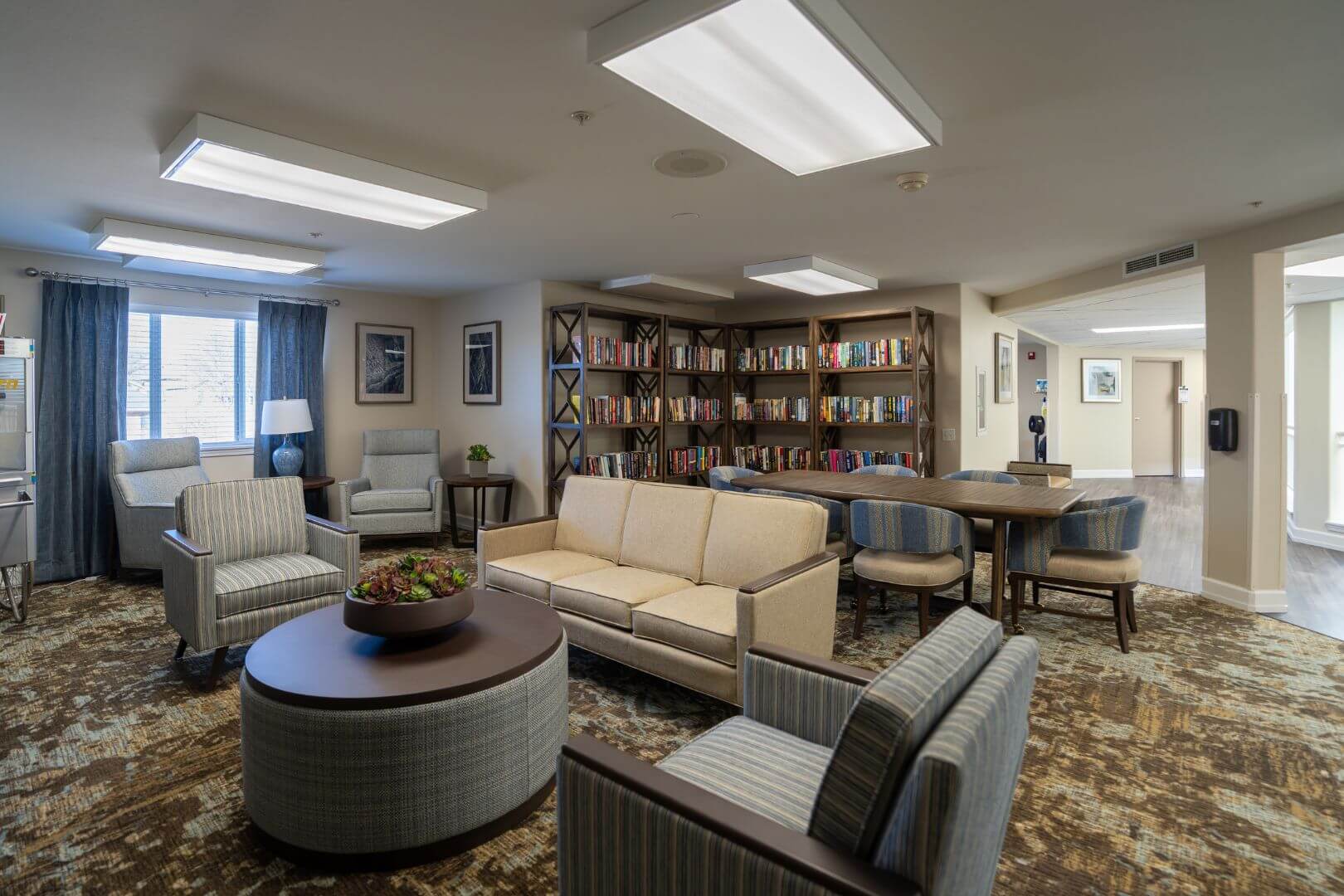 Comfortable Library Lounge with Bookshelves and Soft Sofas in Our Independent Living Facility