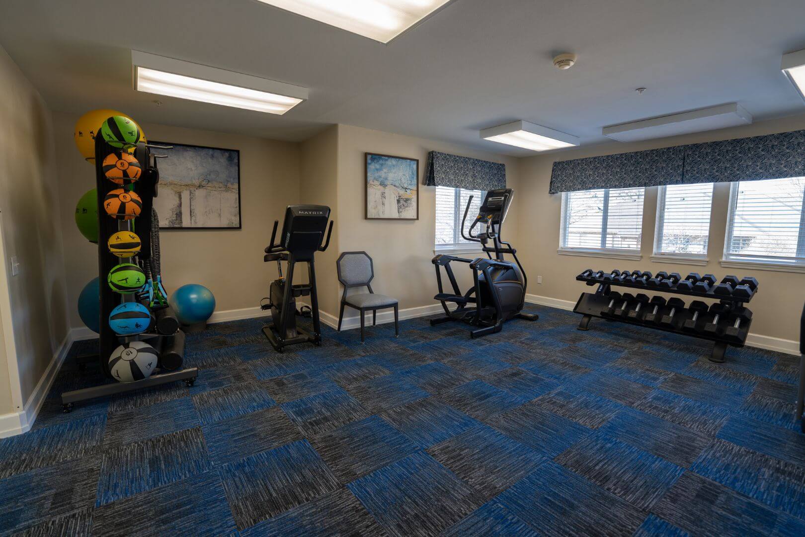 Equipped Fitness Room with Cardio Machines and Free Weights in Our Independent Living Facility