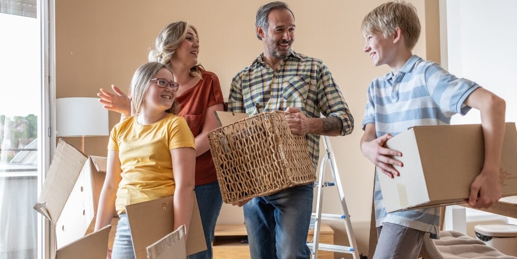 Family Carrying Moving Boxes into New Independent Living Facility Home